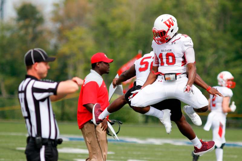 a football player carrying another player in the air
