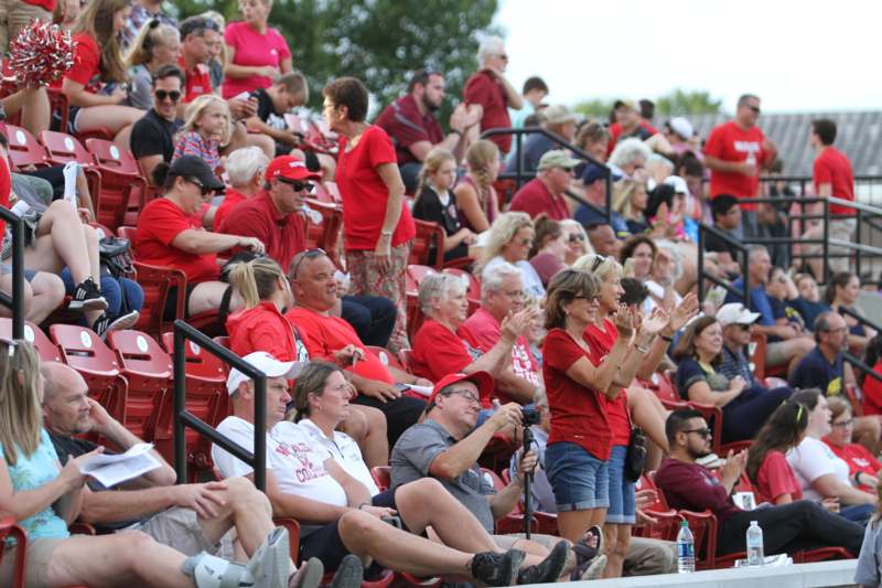 a group of people in red shirts in bleachers