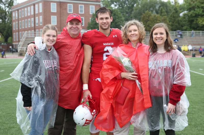 a group of people wearing red ponchos and standing on a field