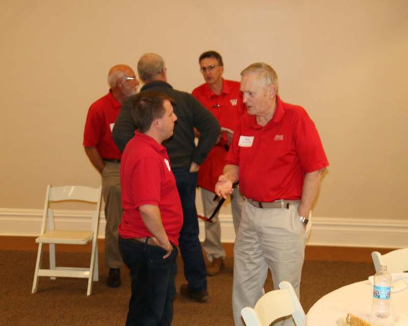 a group of men in red shirts talking