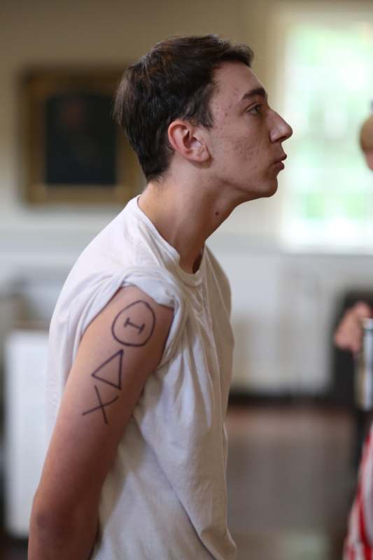 a man in a white shirt with a tattoo on his arm