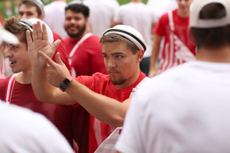 a man in red shirt and white hat giving high five