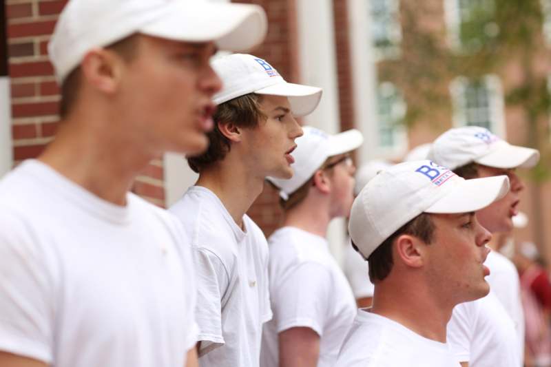 a group of men wearing white shirts and hats