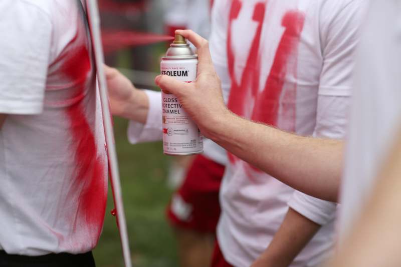 a person spraying red paint on a shirt