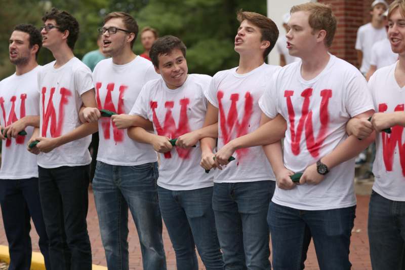 a group of men wearing white t-shirts with red letters on them