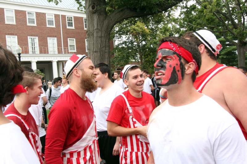 a group of men wearing red and white striped hats and face paint