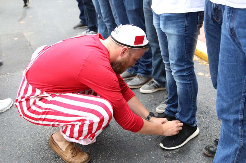 a man wearing a hat and tying his shoes