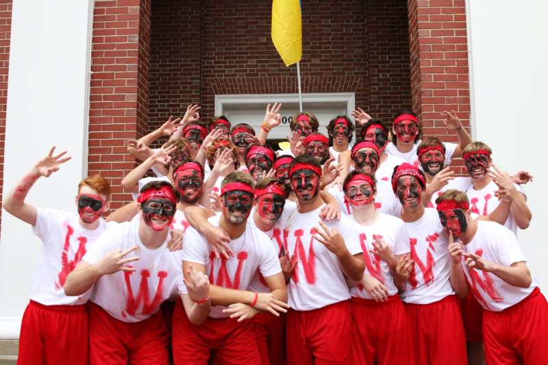 a group of people wearing red and white t-shirts with painted face