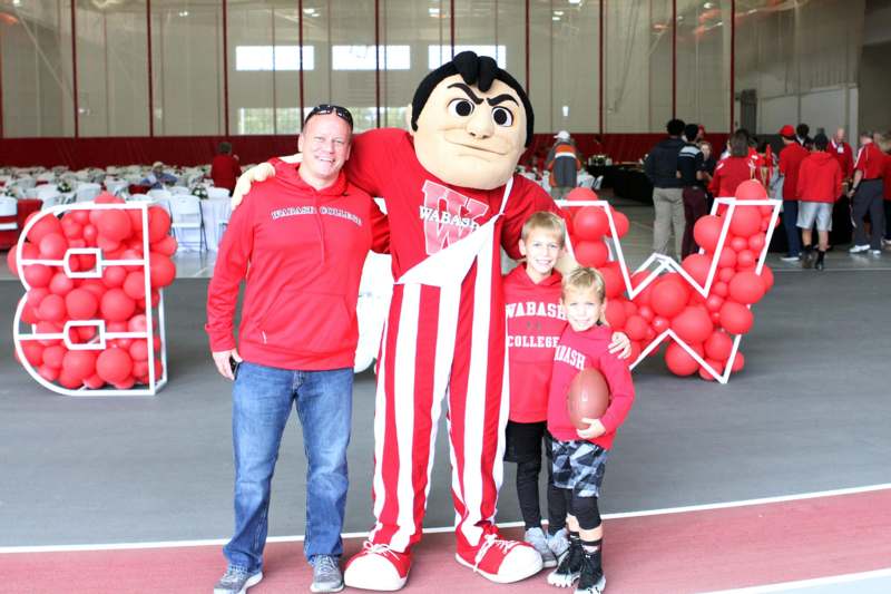 a man and two children posing with a mascot