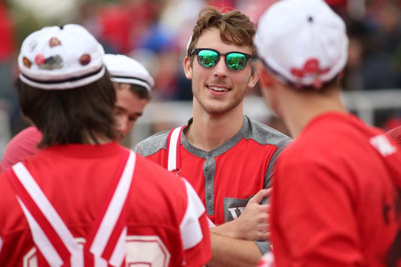 a man in red and green sunglasses with other people in the back