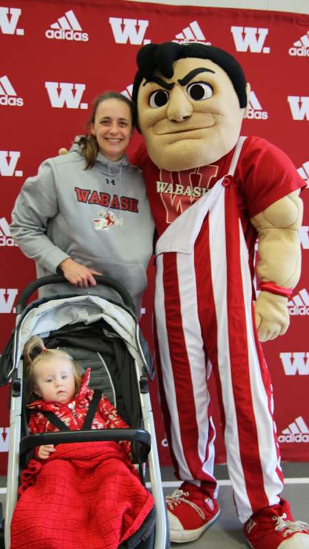 a woman and a child posing with a mascot