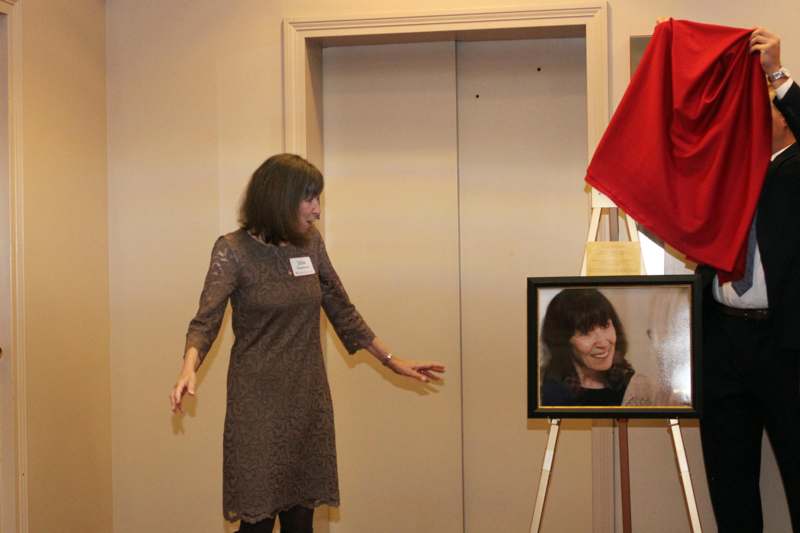 a woman standing next to a picture of a woman