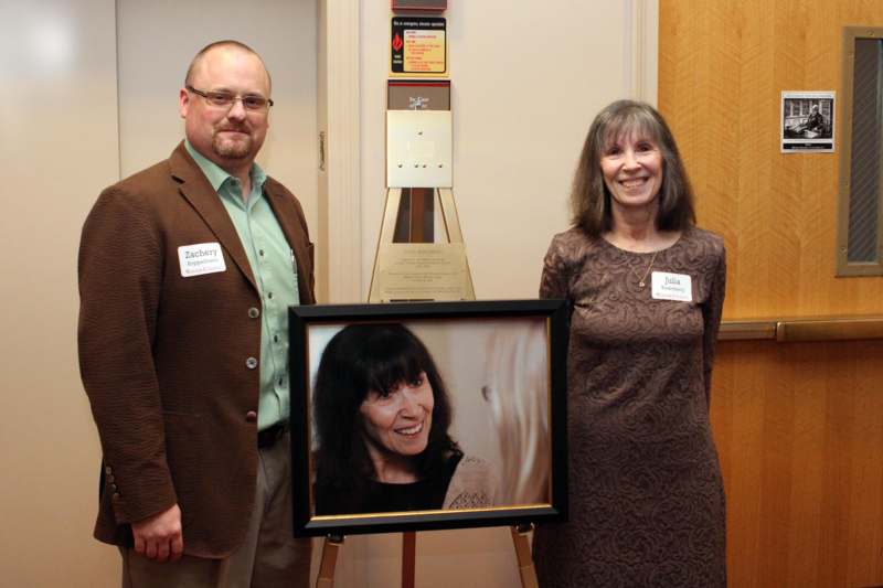 a man and woman standing next to a framed picture