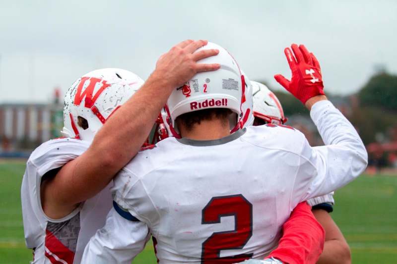 a group of football players huddle
