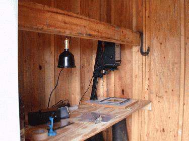 a wooden desk with a lamp and a gun
