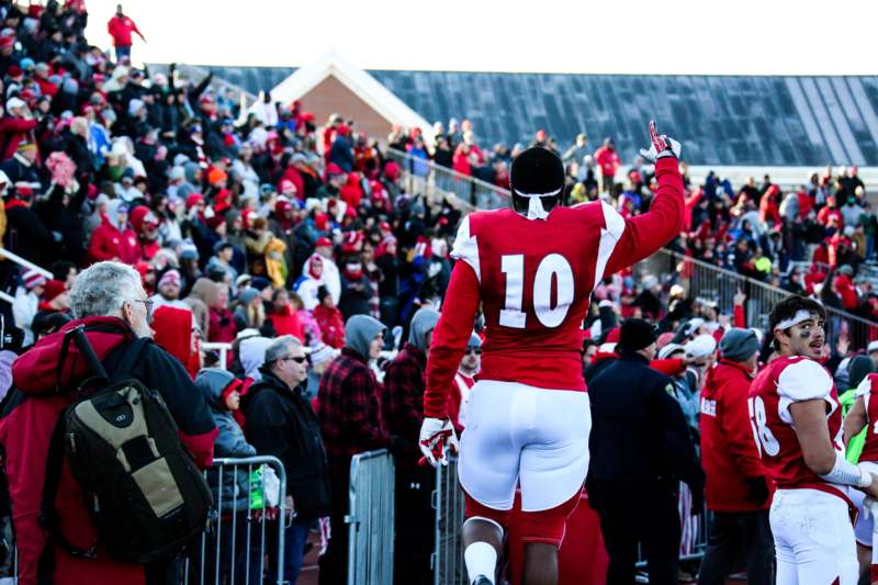 a football player in a red uniform with a crowd watching