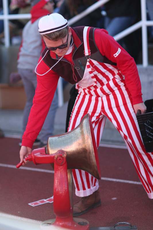 a man wearing red and white striped overalls and holding a horn