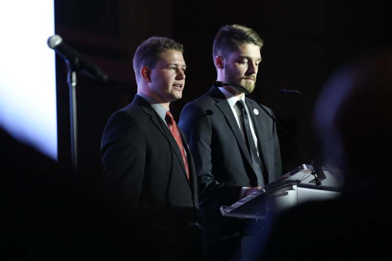 two men standing at a podium