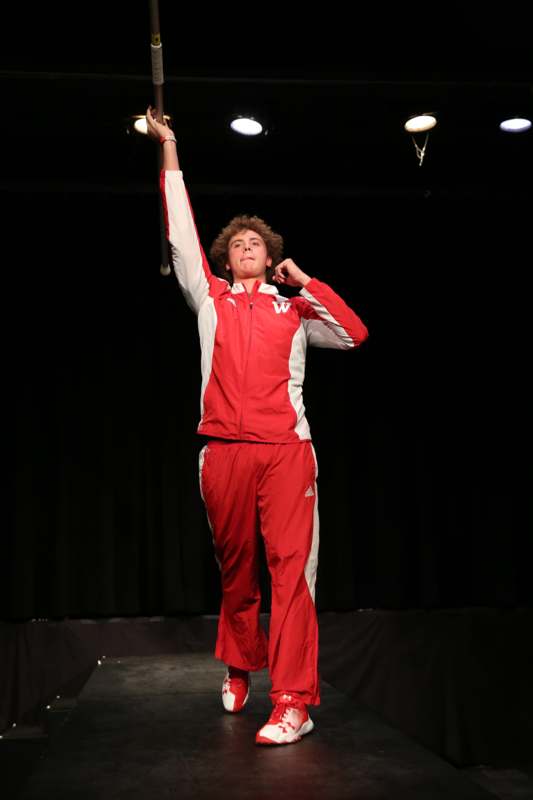 a man in red tracksuit holding a bat