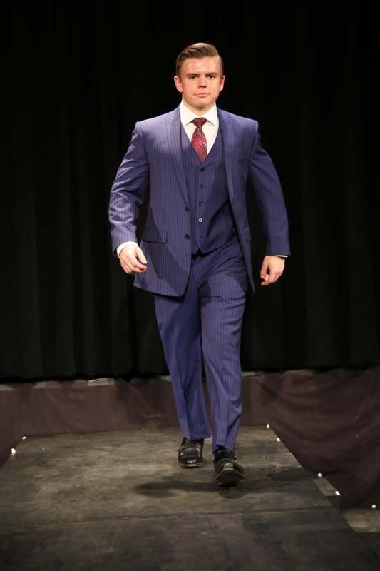 a man in a suit walking on a stage