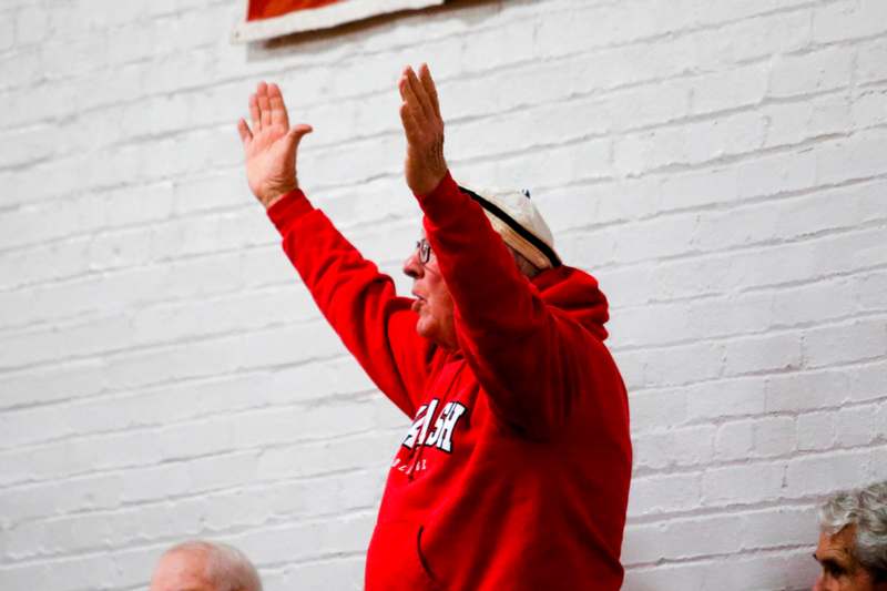 a man in a red hoodie raising his hands