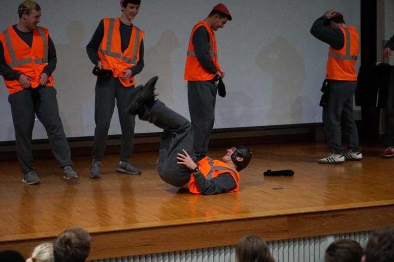a man falling on the floor with other people in the background