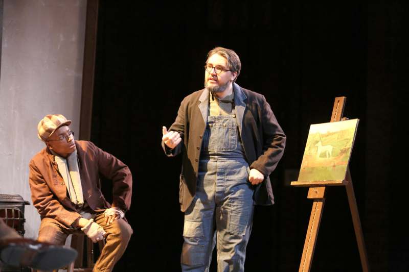 a man standing next to a man on a stage