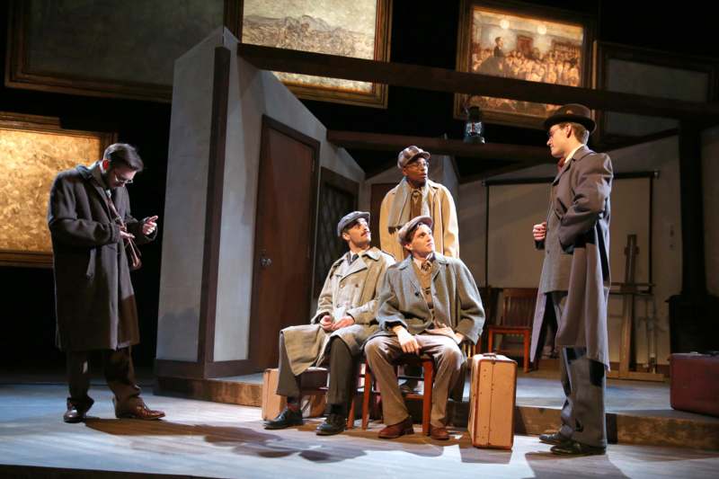 a group of men in coats on a stage