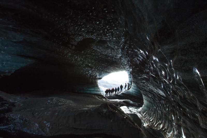 a group of people walking through a cave