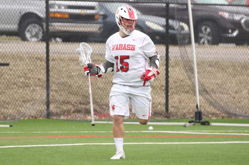 a man wearing a helmet and holding a lacrosse stick