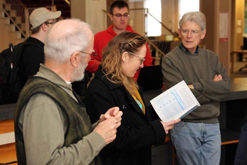a group of people standing around a book