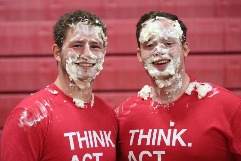 two men with whipped cream on their faces