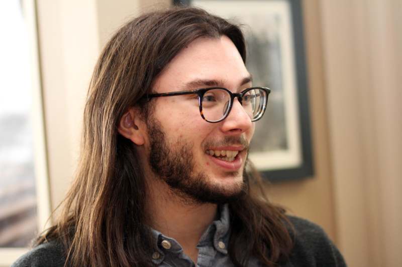 a man with long hair and glasses