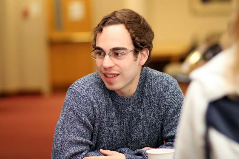 a man wearing glasses and a sweater