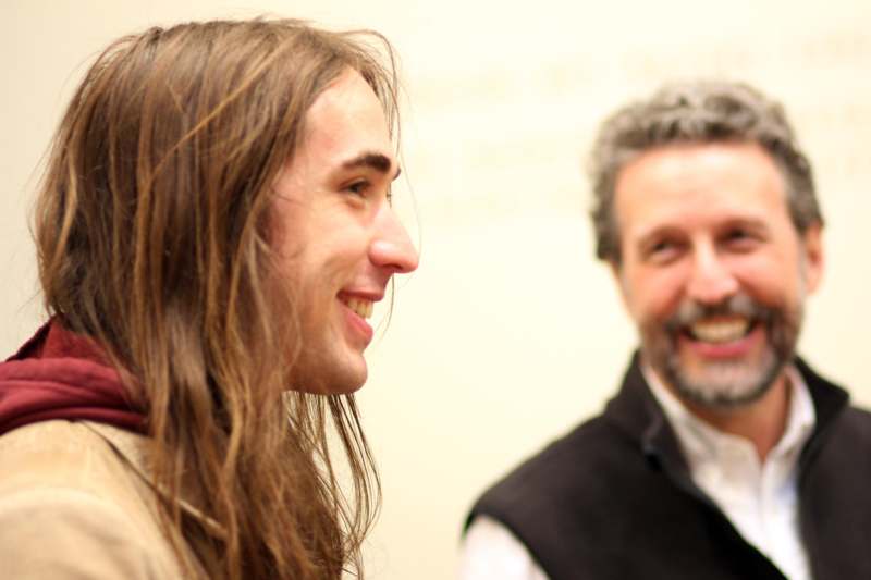 a man with long hair and a man with long hair smiling