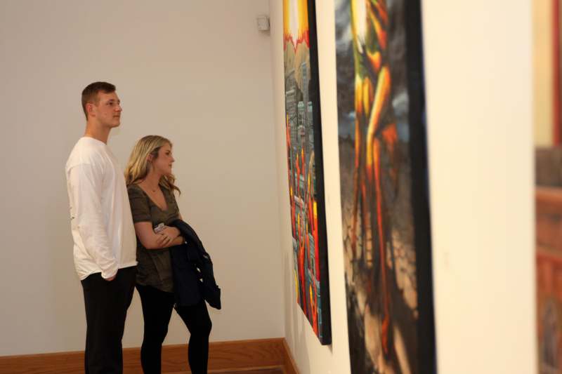a man and woman looking at art