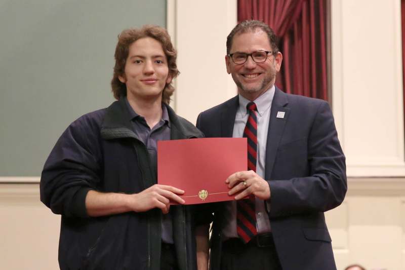 two men holding a red certificate