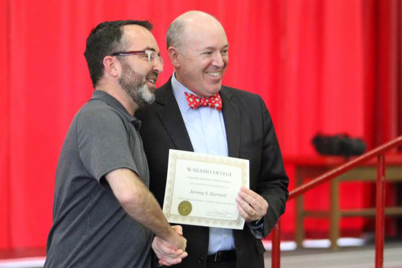 a man holding a certificate and smiling
