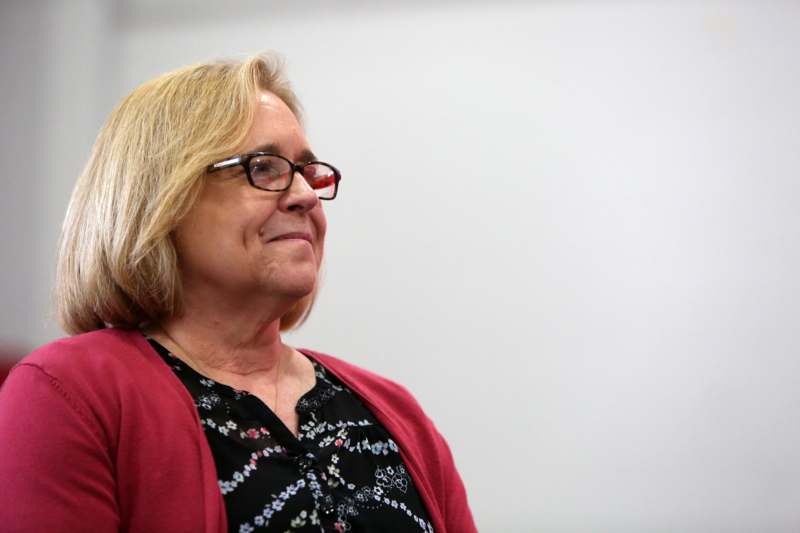 a woman wearing glasses and a red cardigan