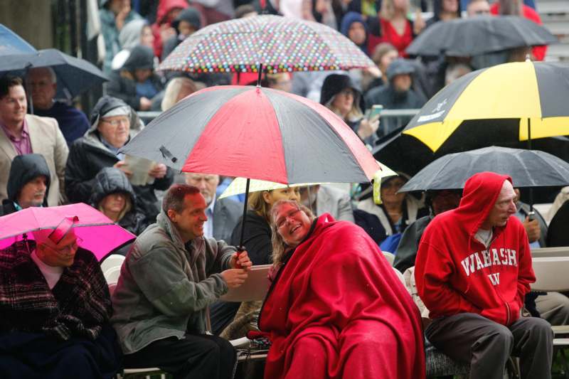 a group of people sitting under umbrellas