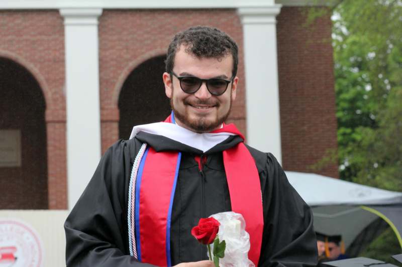 a man wearing a graduation gown and sunglasses
