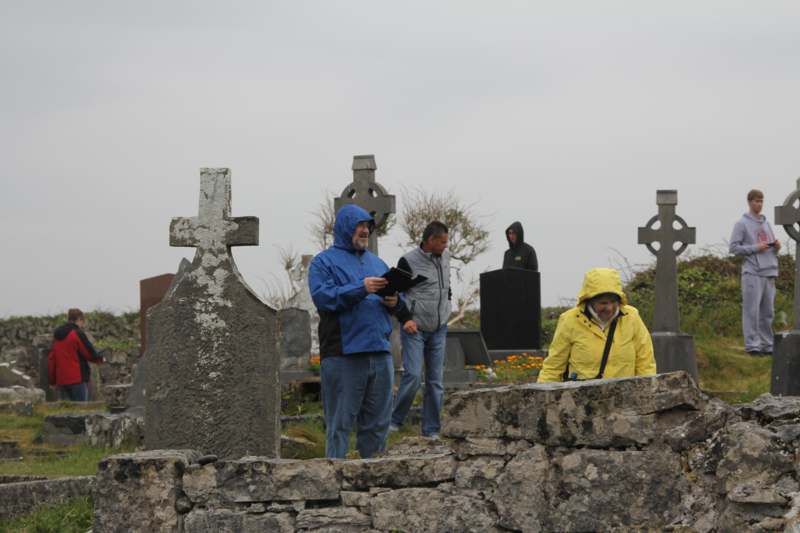 a group of people standing in a cemetery