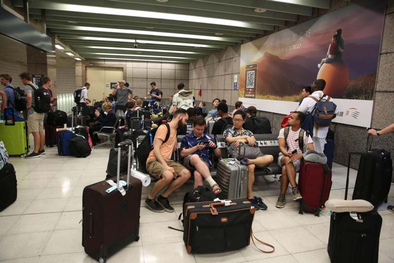 a group of people sitting on benches with luggage