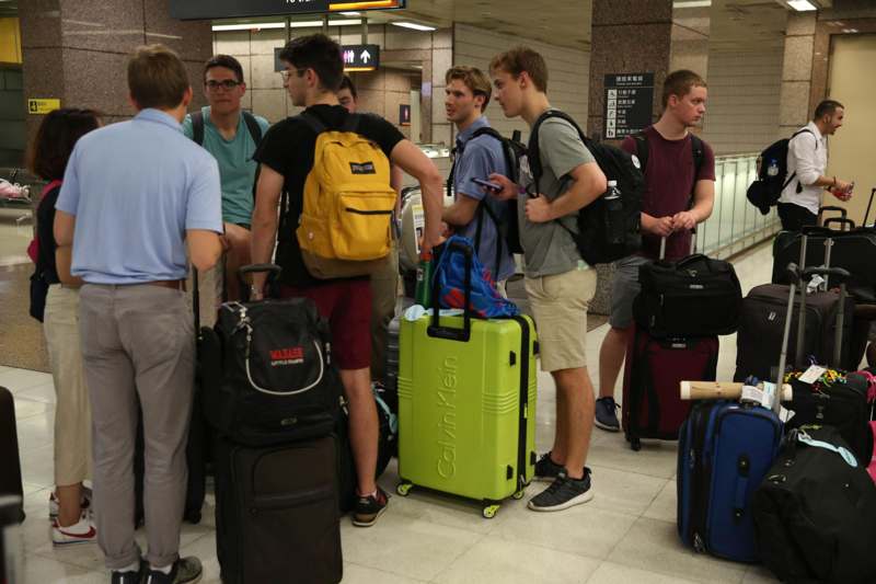 a group of people standing in a room with luggage