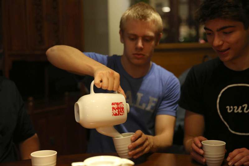 a man pouring milk into a white cup