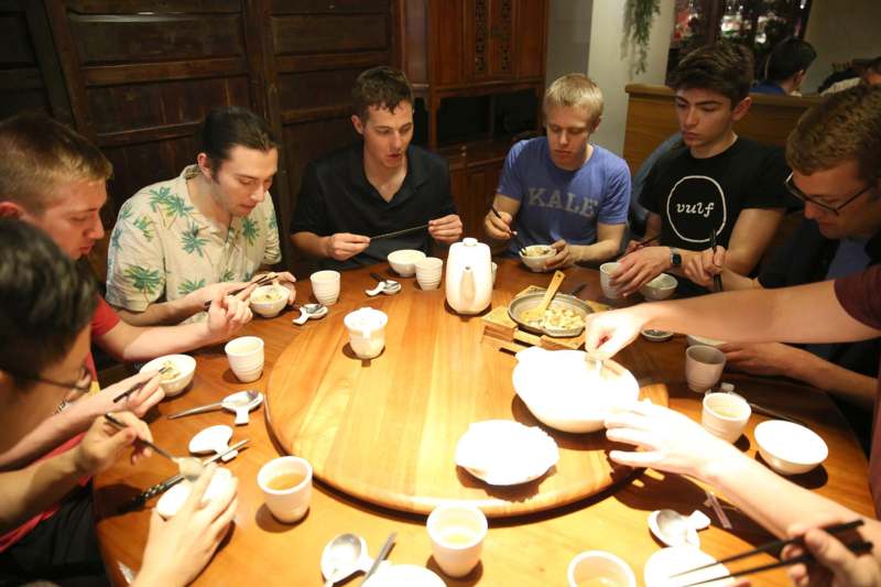 a group of people around a table eating food