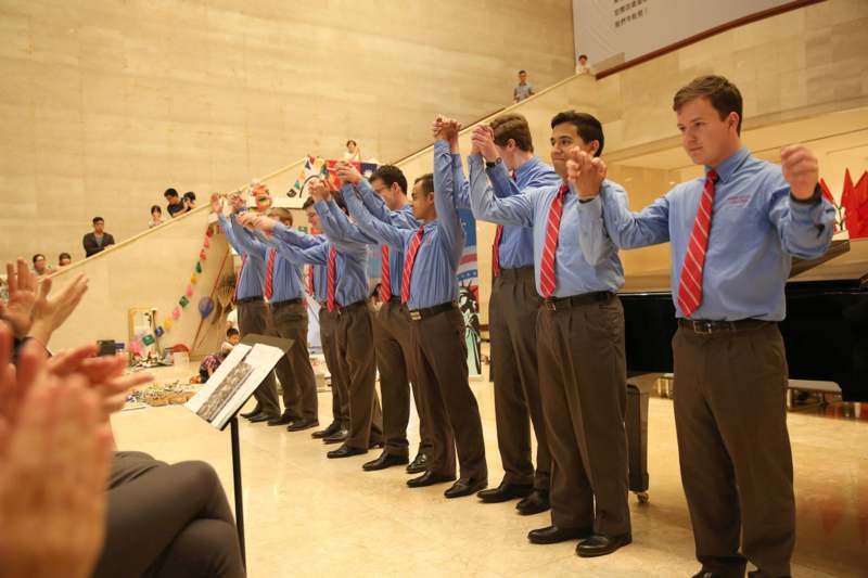 a group of men in blue shirts and red ties