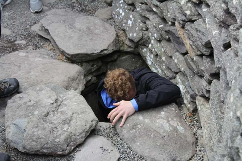 a man hiding in a hole in rocks
