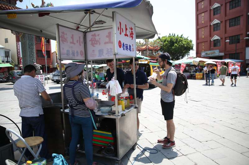a group of people standing in front of a food cart