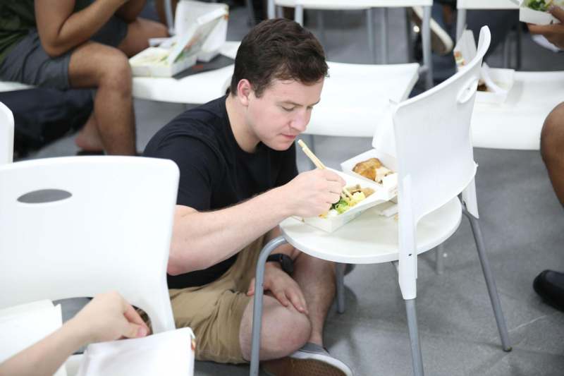 a man sitting on the floor eating food